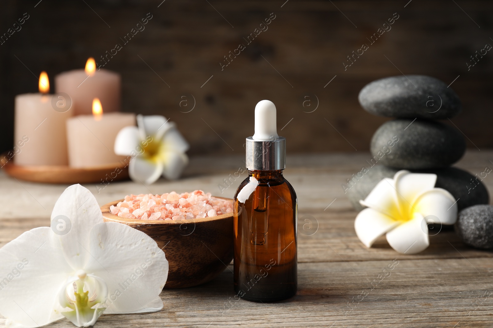 Composition with cosmetic product and spa stones on wooden table, closeup Photo of Composition with cosmetic product and spa stones on wooden table, closeup