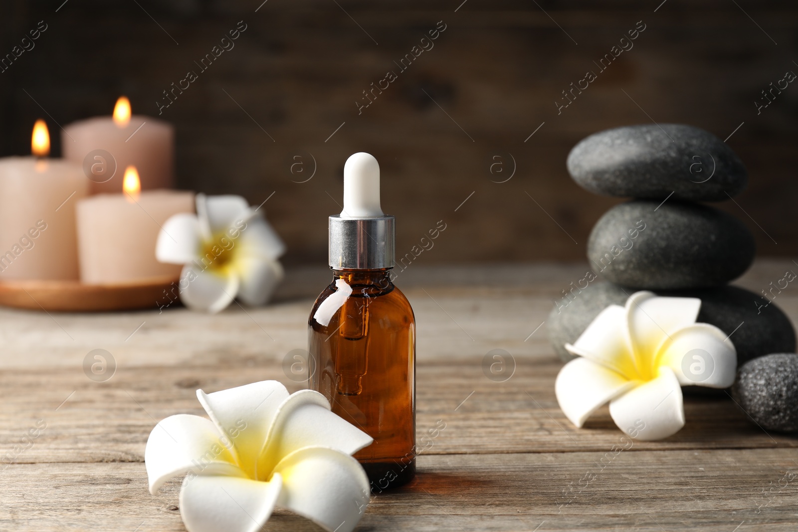 Composition with cosmetic product and spa stones on wooden table, closeup Photo of Composition with cosmetic product and spa stones on wooden table, closeup