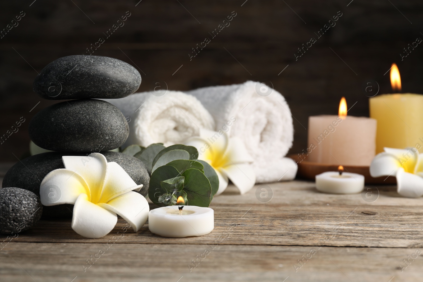 Photo of Composition with spa stones on wooden table, closeup