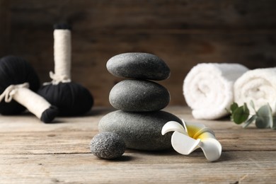 Photo of Composition with spa stones on wooden table, closeup