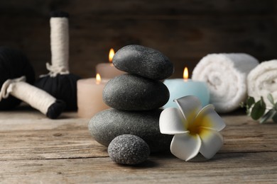 Photo of Composition with spa stones on wooden table, closeup