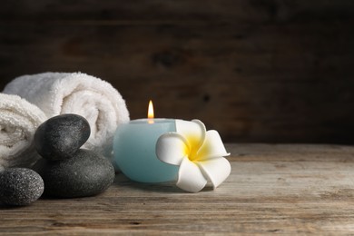 Photo of Composition with spa stones on wooden table, closeup. Space for text