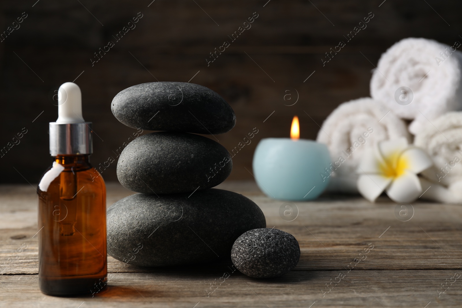 Composition with cosmetic product and spa stones on wooden table, closeup Photo of Composition with cosmetic product and spa stones on wooden table, closeup