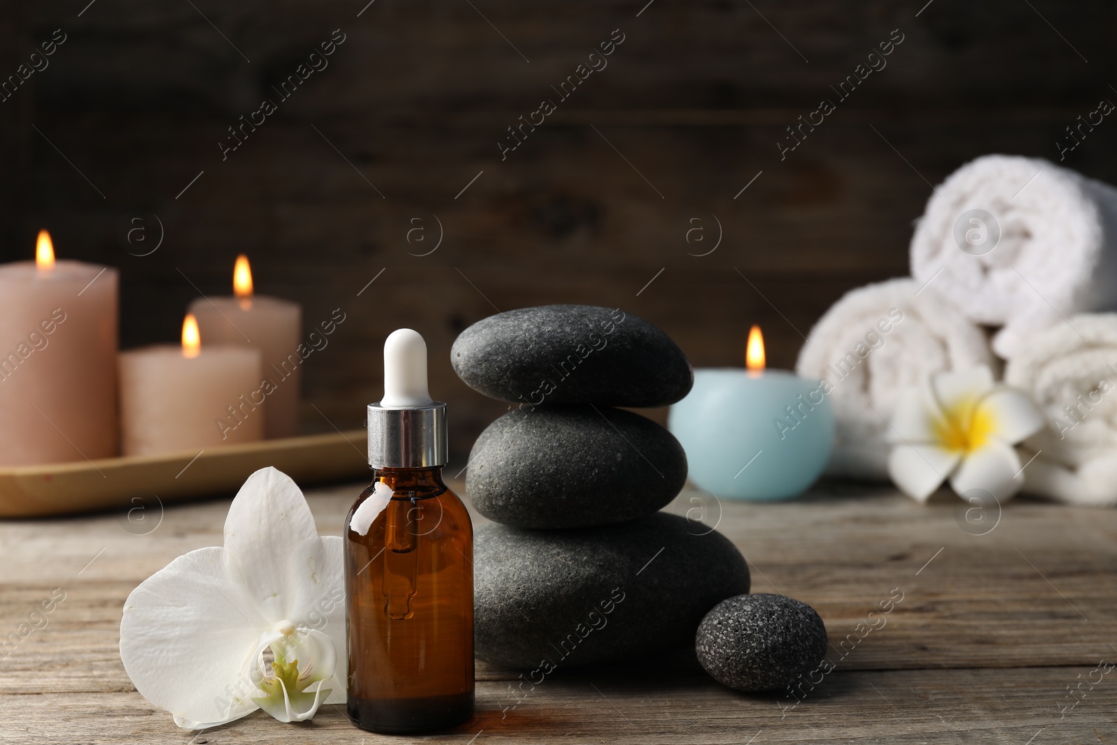 Composition with cosmetic product and spa stones on wooden table, closeup Photo of Composition with cosmetic product and spa stones on wooden table, closeup