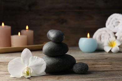Photo of Composition with spa stones on wooden table, closeup