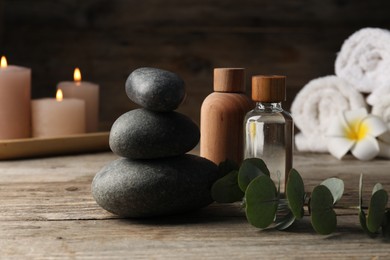 Photo of Composition with cosmetic products and spa stones on wooden table, closeup