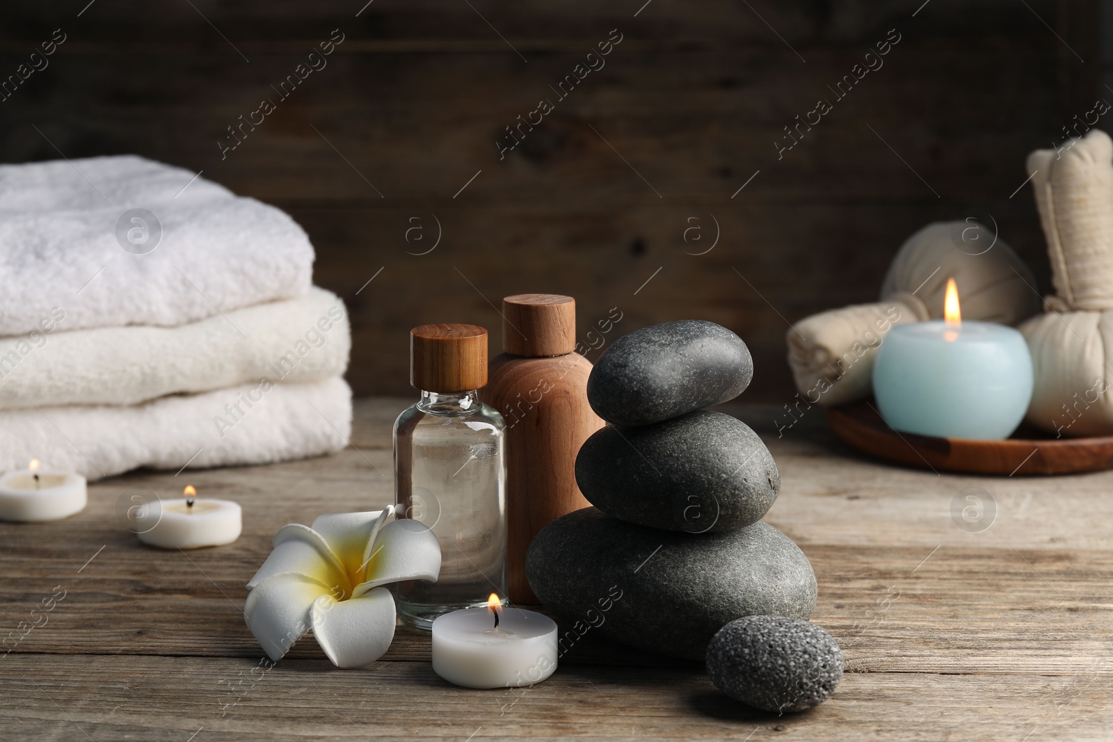 Composition with cosmetic products and spa stones on wooden table, closeup Photo of Composition with cosmetic products and spa stones on wooden table, closeup