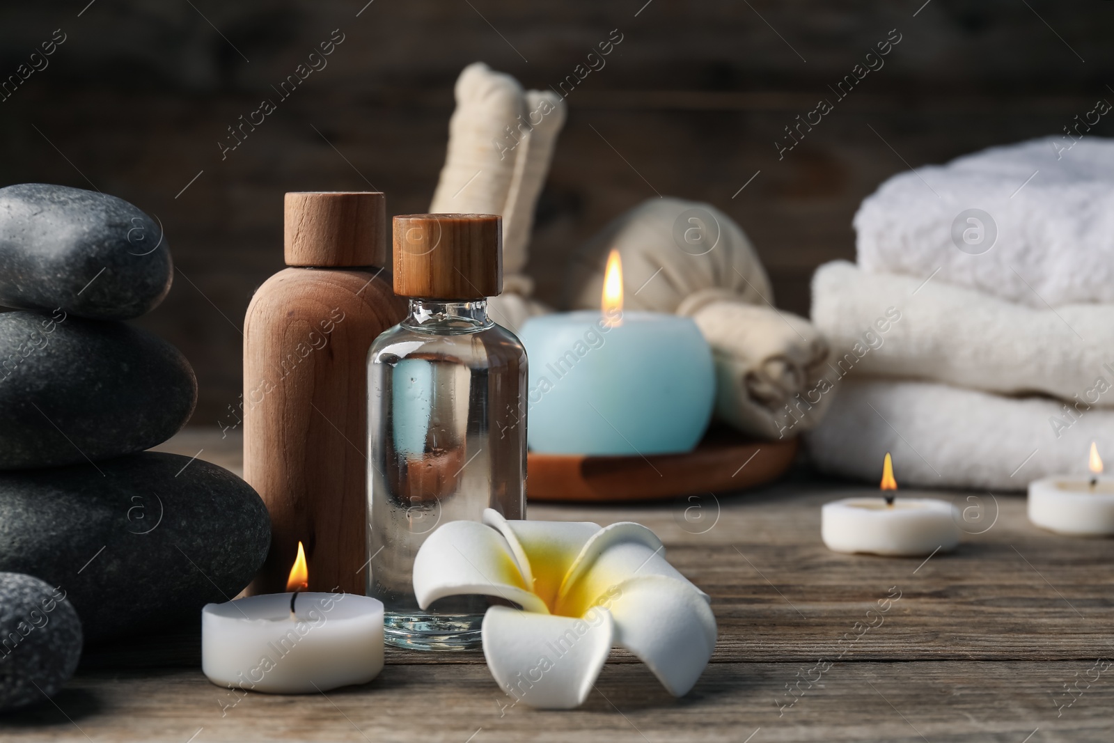Composition with cosmetic products and spa stones on wooden table, closeup Photo of Composition with cosmetic products and spa stones on wooden table, closeup