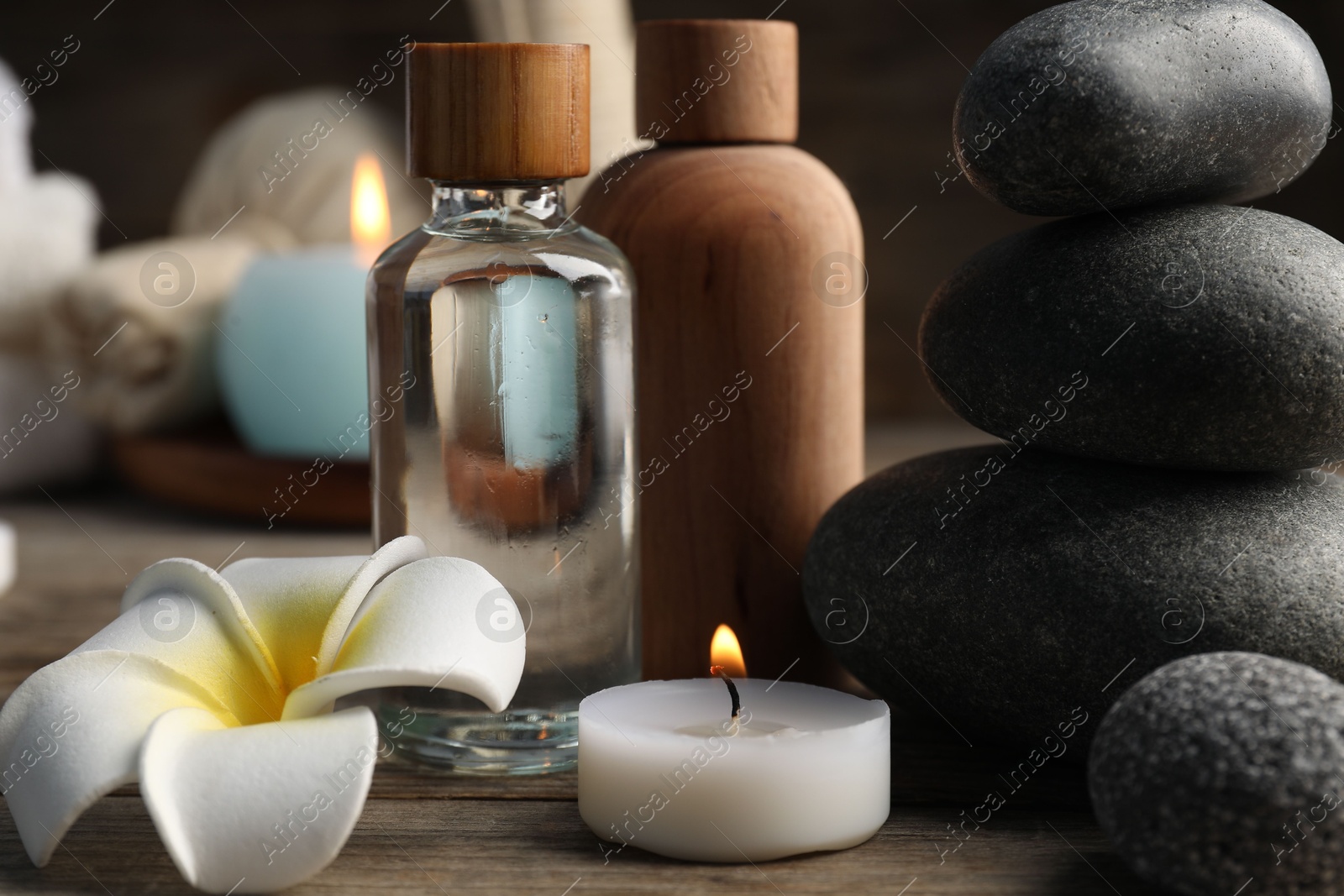Composition with cosmetic products and spa stones on wooden table, closeup Photo of Composition with cosmetic products and spa stones on wooden table, closeup