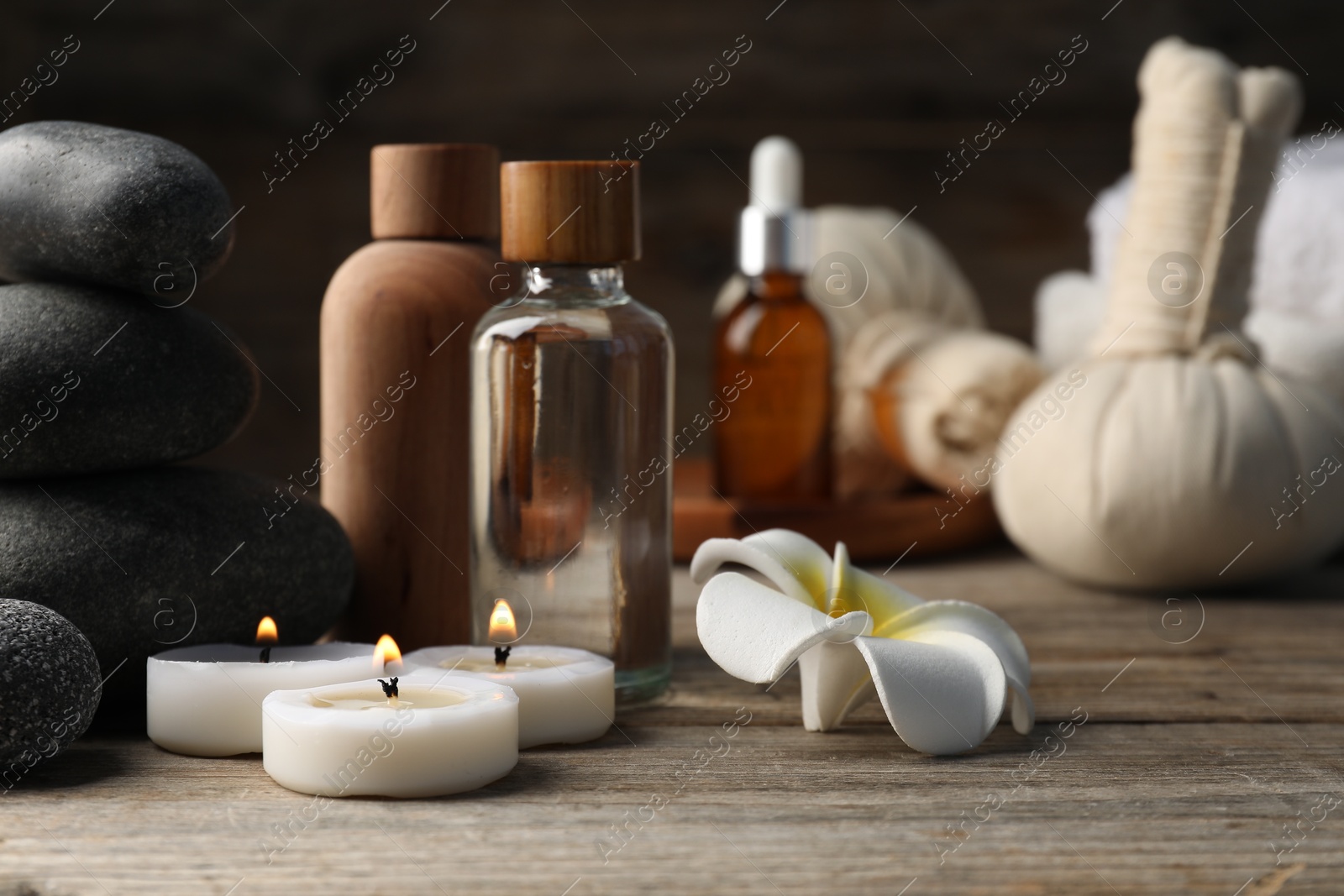 Composition with cosmetic products and spa stones on wooden table, closeup Photo of Composition with cosmetic products and spa stones on wooden table, closeup