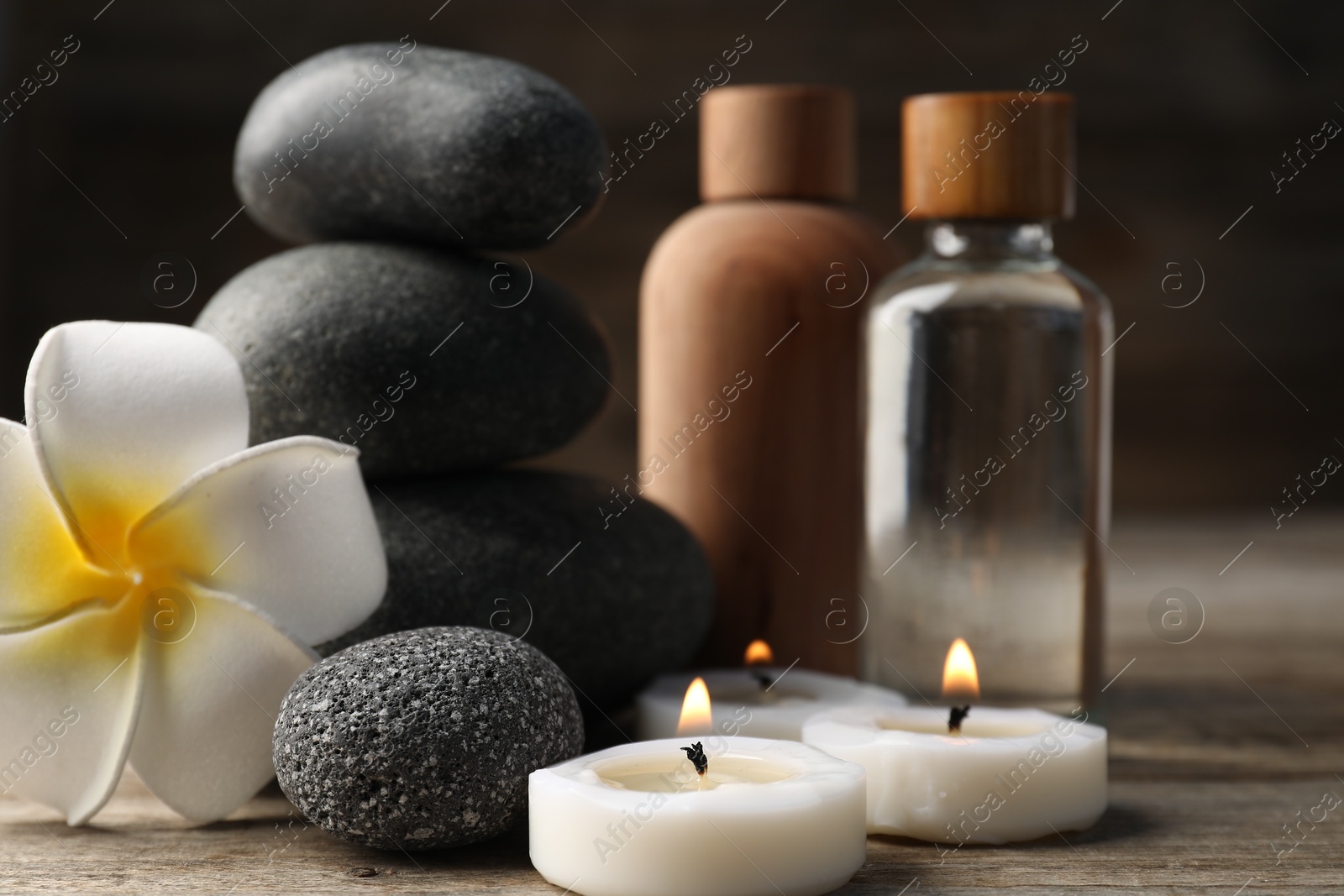 Composition with cosmetic products and spa stones on wooden table, closeup Photo of Composition with cosmetic products and spa stones on wooden table, closeup