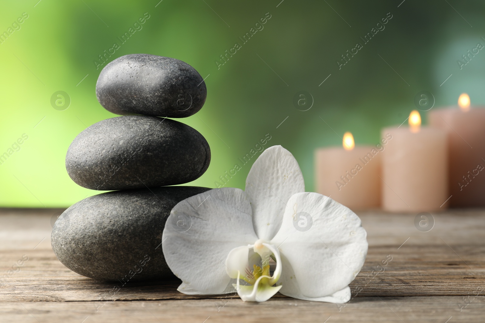 Spa stones and orchid flower on wooden table, closeup Photo of Spa stones and orchid flower on wooden table, closeup