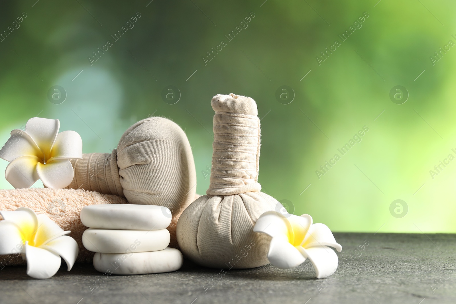 Composition with spa stones and herbal bags on grey table, closeup. Space for text Photo of Composition with spa stones and herbal bags on grey table, closeup. Space for text