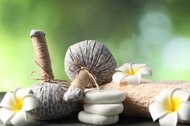 Photo of Composition with spa stones and herbal bags on grey table, closeup