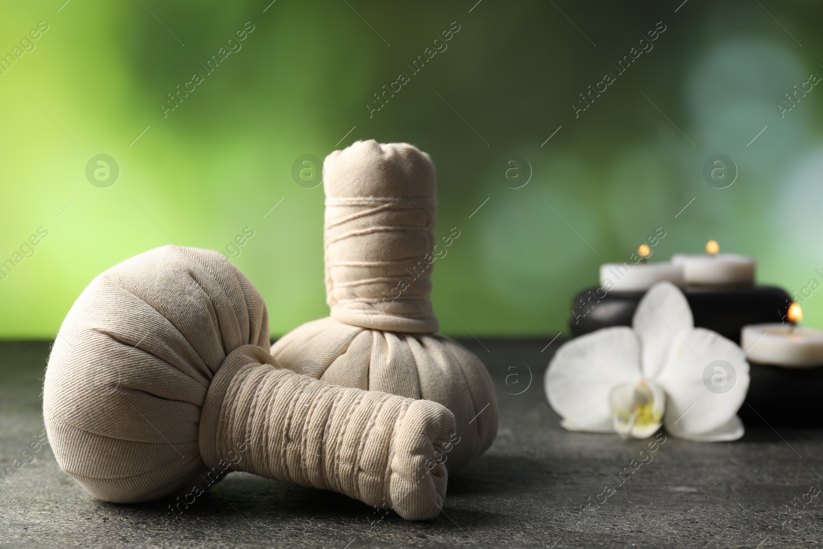 Composition with spa stones and herbal bags on grey table, closeup Photo of Composition with spa stones and herbal bags on grey table, closeup