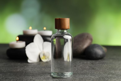 Photo of Composition with cosmetic product and spa stones on grey table, closeup