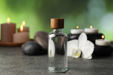 Photo of Composition with cosmetic product and spa stones on grey table, closeup