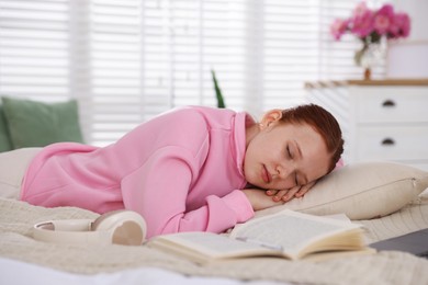 Photo of Tired teenage student sleeping on bed at home