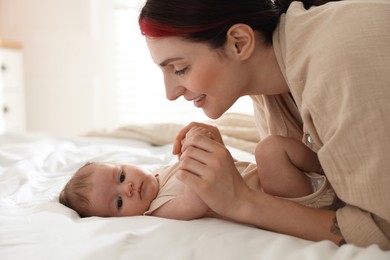 Photo of Mother with her newborn baby on bed indoors