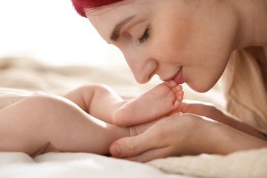 Photo of Mother with her newborn baby on bed indoors, closeup