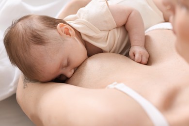 Photo of Mother breastfeeding her newborn baby indoors, above view