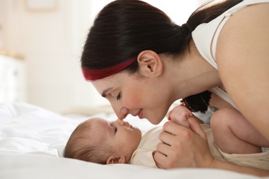 Photo of Mother with her newborn baby on bed indoors