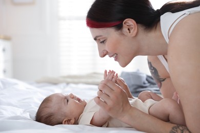Photo of Mother with her newborn baby on bed indoors
