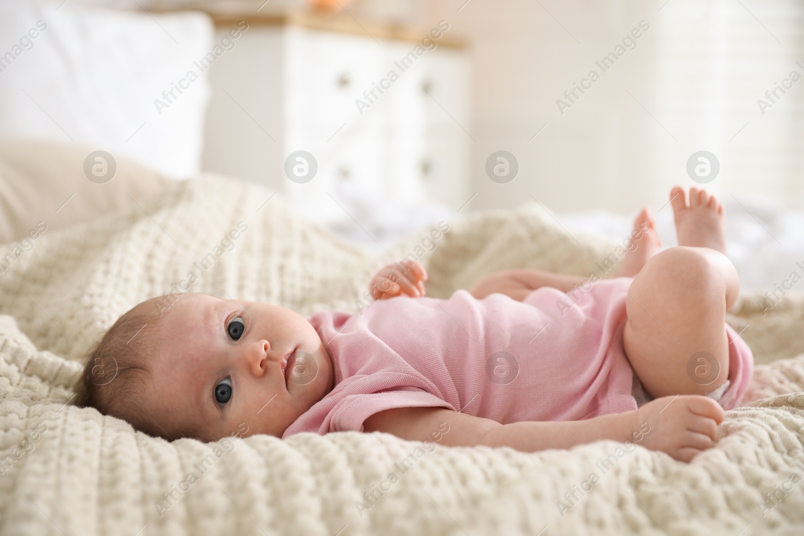 Cute newborn baby lying on bed indoors Photo of Cute newborn baby lying on bed indoors
