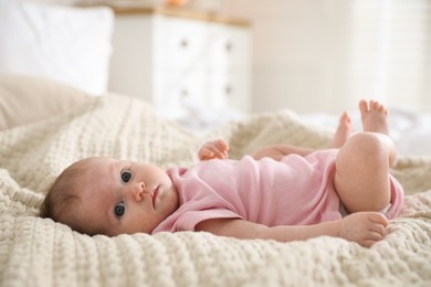 Photo of Cute newborn baby lying on bed indoors