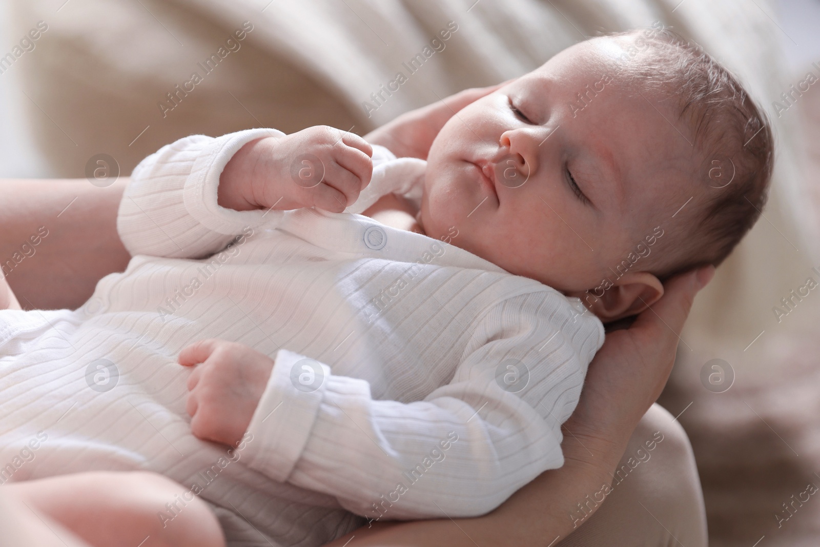 Mom holding her sleeping newborn baby at home, closeup Photo of Mom holding her sleeping newborn baby at home, closeup