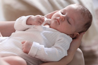 Photo of Mom holding her sleeping newborn baby at home, closeup