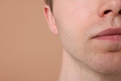 Photo of Man after shaving on beige background, closeup. Space for text
