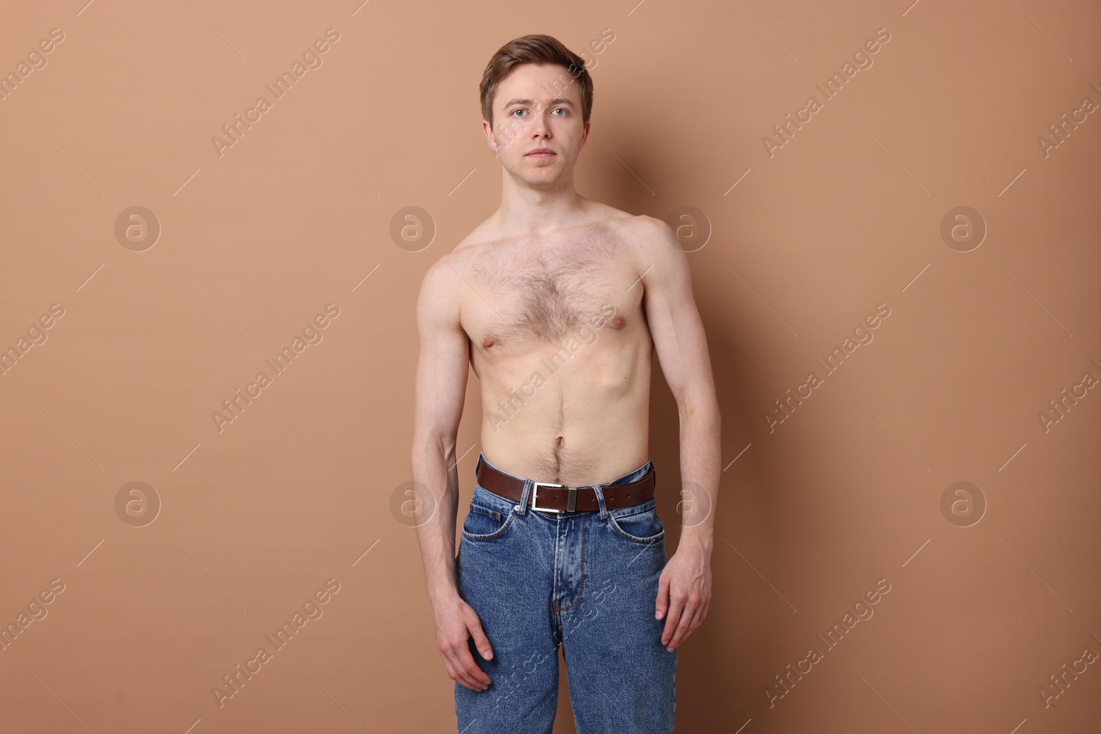 Man before scoliosis treatment on beige background Photo of Man before scoliosis treatment on beige background