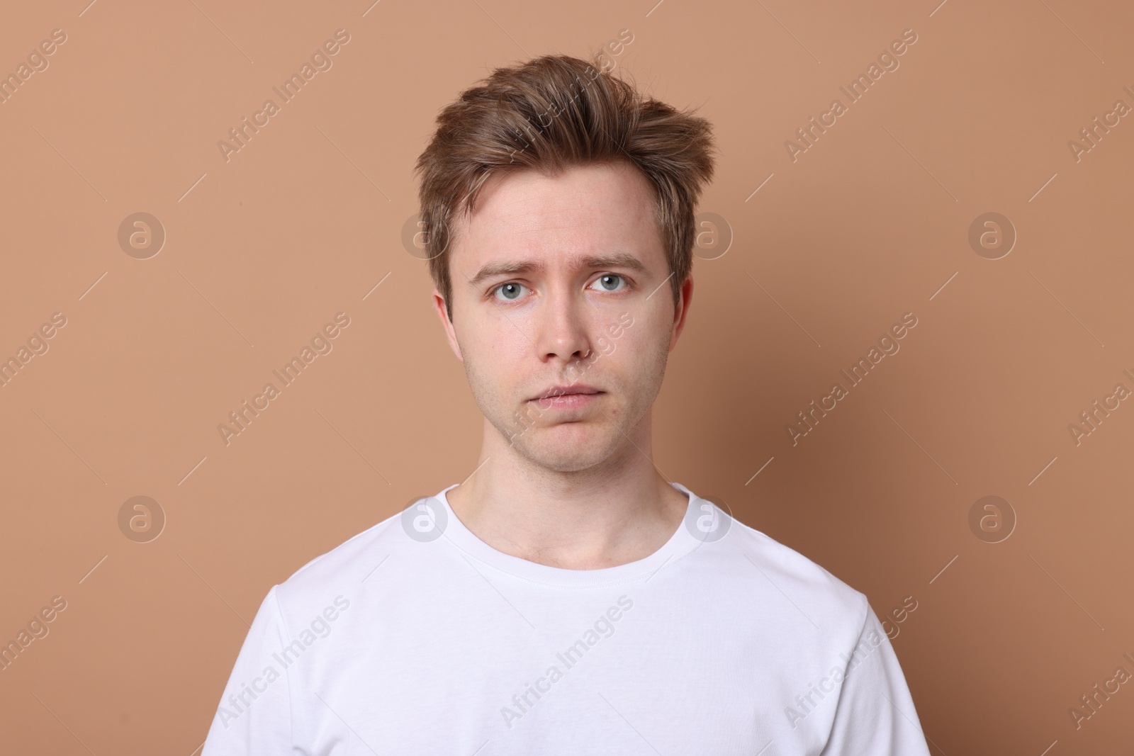 Handsome man after shaving on beige background Photo of Handsome man after shaving on beige background