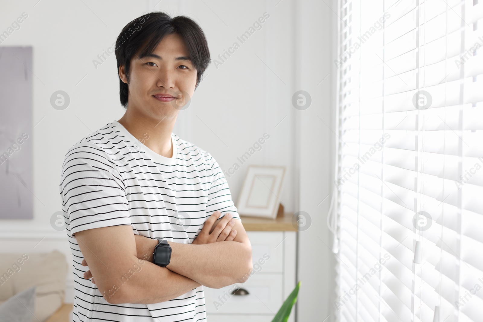Portrait of handsome Asian man with crossed arms at home. Space for text Photo of Portrait of handsome Asian man with crossed arms at home. Space for text