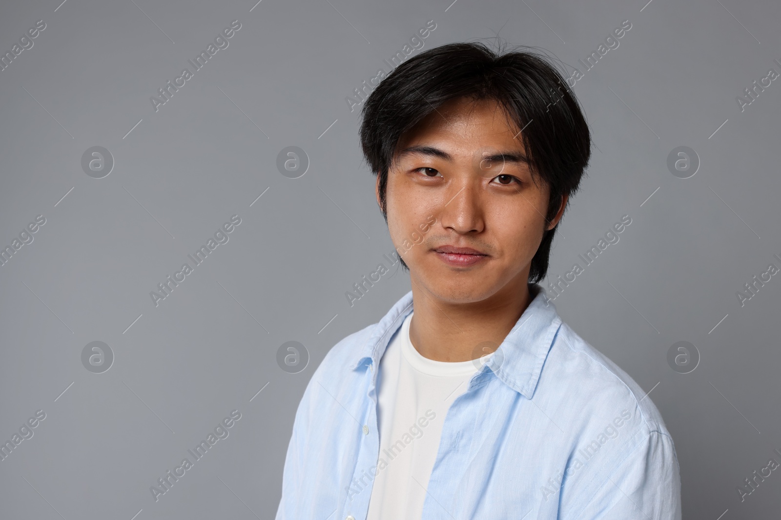 Portrait of handsome Asian man on grey background. Space for text Photo of Portrait of handsome Asian man on grey background. Space for text