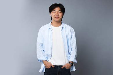 Photo of Portrait of handsome Asian man on grey background