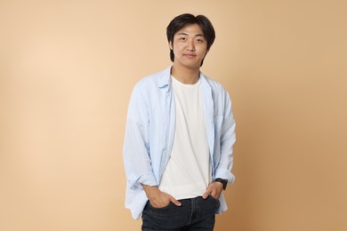 Photo of Portrait of handsome Asian man on beige background
