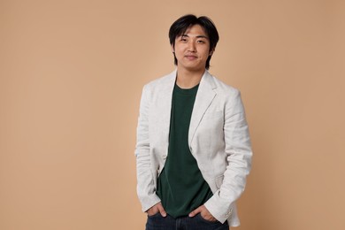 Photo of Portrait of handsome Asian businessman in suit on beige background