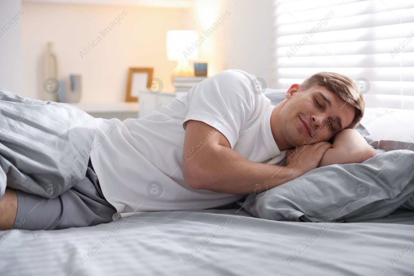 Young man sleeping on bed with soft mattress at home Photo of Young man sleeping on bed with soft mattress at home