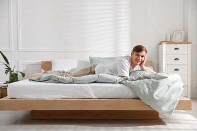 Photo of Young man lying on bed with soft mattress at home