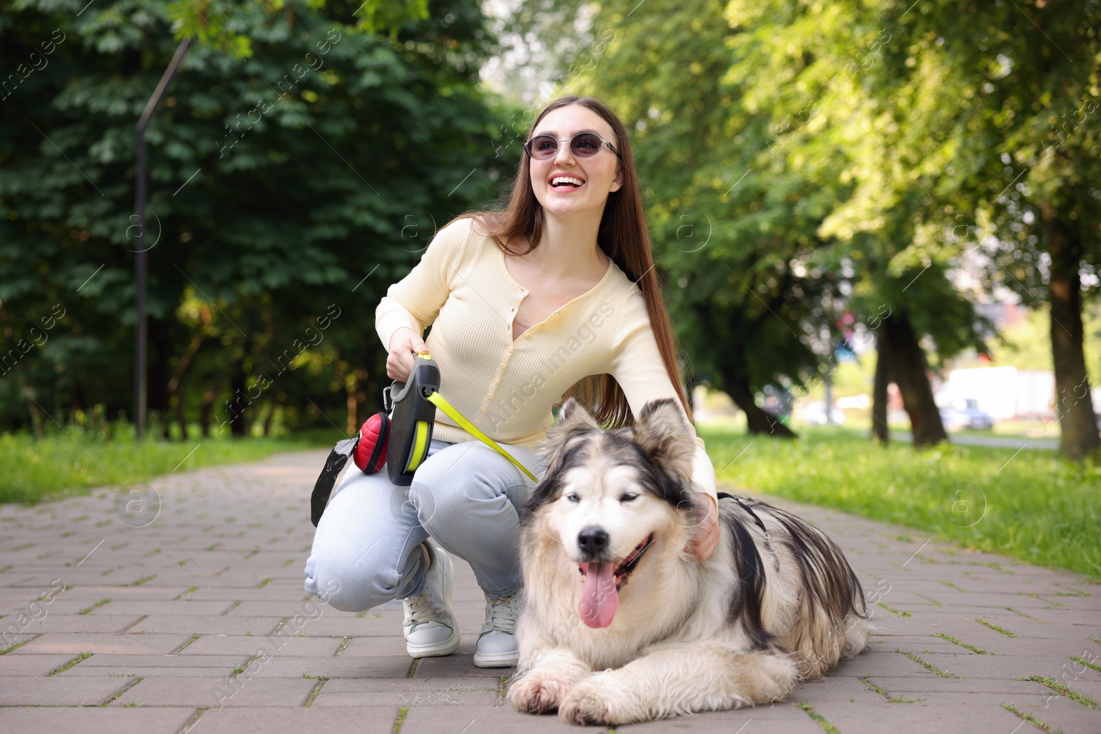 Happy woman with her cute Alaskan malamute dog in park Photo of Happy woman with her cute Alaskan malamute dog in park