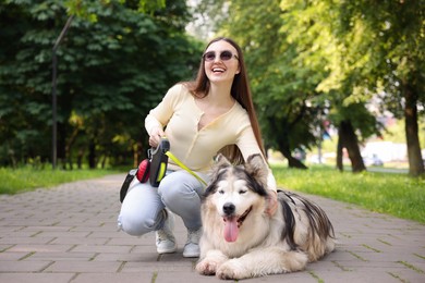 Photo of Happy woman with her cute Alaskan malamute dog in park