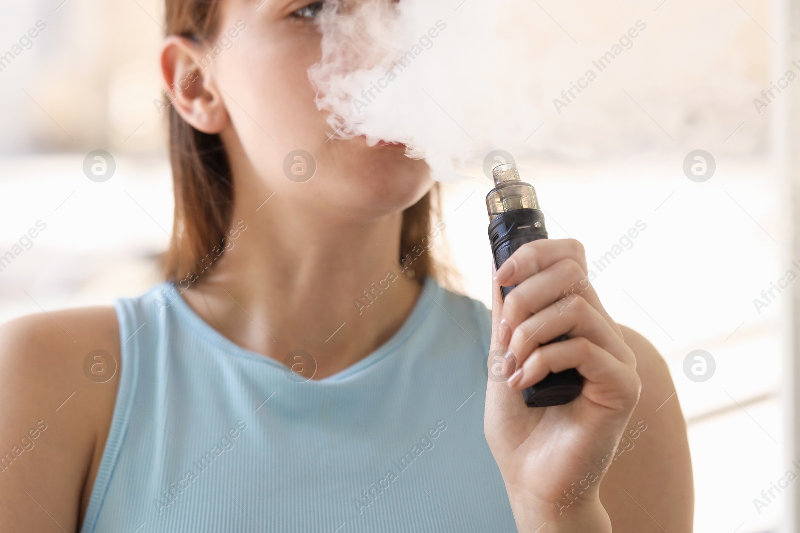 Young woman using electronic smoking device outdoors, closeup Photo of Young woman using electronic smoking device outdoors, closeup