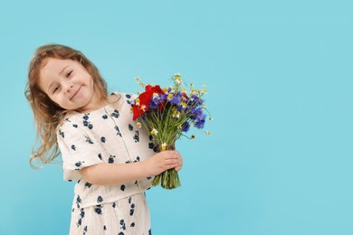 Photo of Cute little girl with bouquet of beautiful flowers on light blue background, space for text