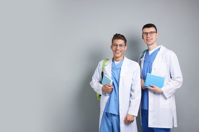 Photo of Medical students with books on light grey background. Space for text