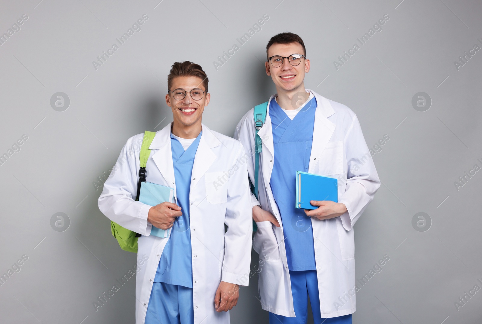 Medical students with books on light grey background Photo of Medical students with books on light grey background