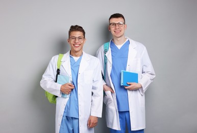 Photo of Medical students with books on light grey background