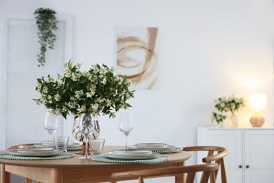 Photo of Bouquet of beautiful jasmine flowers on dining table indoors. Space for text