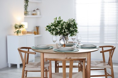 Photo of Bouquet of beautiful jasmine flowers on dining table indoors